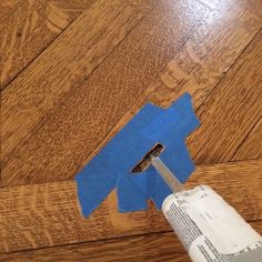 a piece of blue paper is cut into the shape of a bird on top of a wooden floor