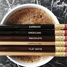 five pencils sitting on top of a white bowl