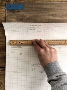 a person is measuring the height of a piece of paper with a ruler on it