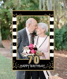 an older couple standing next to each other in front of a black and white photo