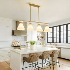 a kitchen with white cabinets and an island in the middle, surrounded by stools