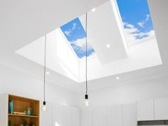 an open kitchen with skylights and white cabinets