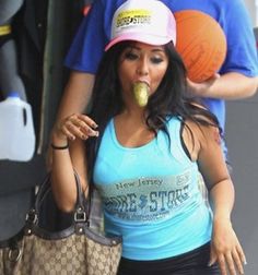 a woman with an apple in her mouth walking down the street while holding a purse