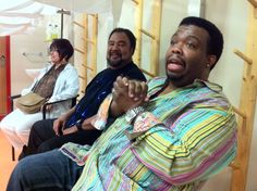 three men sitting in a room with wooden ladders