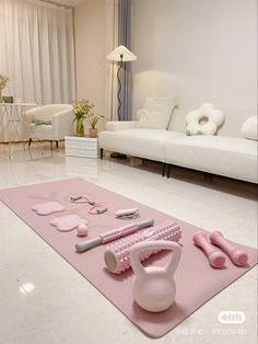 a living room filled with white furniture and pink accessories on top of a rug in front of a couch