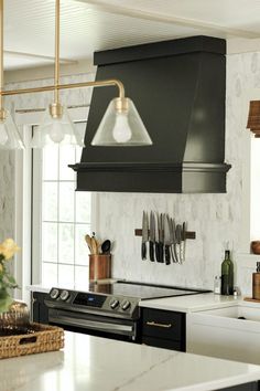 a kitchen with an oven, range hood and counter tops in black color is shown