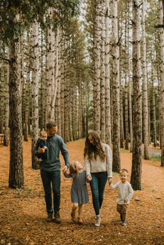 a family walking through the woods holding hands