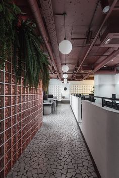 the interior of an office building with plants growing on the wall and tiled flooring