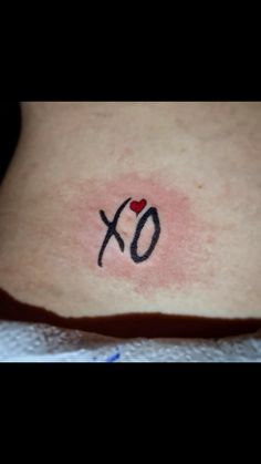 a woman's stomach with the word xo written on it and a red heart