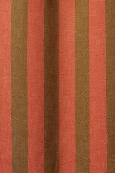 an orange and brown striped curtain hanging from a window