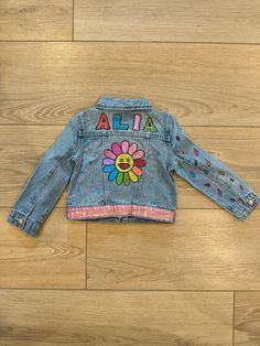 Add a burst of color and joy to your child's wardrobe with our Custom Flower Kids Denim Jacket! Hand-painted with a bright, cheerful flower design and personalized with your child's name, this jacket is perfect for little ones who love to express their colorful personalities. Each piece is crafted to make your child feel unique and special--like the hero of their own story! WHY YOU'LL LOVE IT: - Hand-Painted & Personalized: Every jacket is a unique creation, featuring your child's name and a vib Kids Denim Jacket, Flower Kids, Unique Gifts For Girls, Kids Jackets, Sun Design, Custom Denim, Sun Designs, Kids Denim, Colorful Gifts