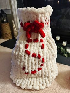 a crocheted vase sitting on top of a table next to a fire place