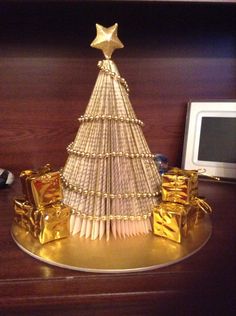 a christmas tree made out of books on top of a desk