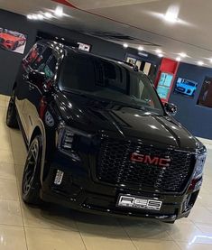 a black suv is parked in a showroom