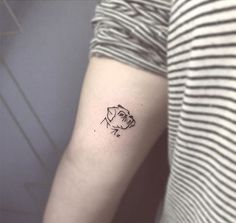 a woman's arm with a small dog tattoo on the left side of her arm