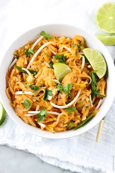 a white bowl filled with pad thai noodles and garnished with cilantro