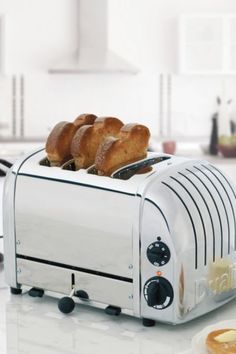 two pieces of bread sit on top of a toaster that is sitting on a counter