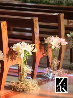 flowers are placed in vases on the pew