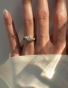 a woman's hand with a diamond ring on it