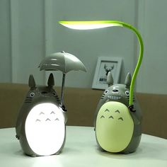 two small toy animals sitting on top of a table next to an open umbrella light