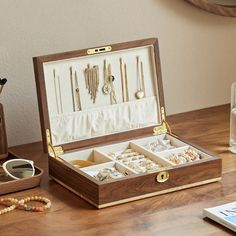 an open wooden jewelry box sitting on top of a table