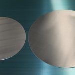 an image of two round objects on a metal surface, one is white and the other is light blue