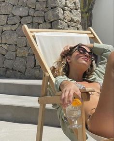 a woman sitting in a chair next to a wall with a wine glass on it