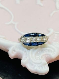 The ring has a lovely structural design with fine openwork filigree, and engravings 5mm wide and sits 4mm high from the finger, with a 1mm shank. Marked PLAT Excellent antique condition Art Deco Oval Sapphire Ring With Prong Setting, Vintage Sapphire Ring With Diamond Cut, Oval Shape, Vintage Oval Sapphire Ring With Diamond Cut, Art Deco Oval Sapphire Ring In Platinum, Collectible Diamond Filigree Rings, Antique Oval Sapphire Ring In Platinum, Oval Art Deco Hallmarked Diamond Ring, Hallmarked Platinum Engraved Ring, Collectible Oval Sapphire Ring In Platinum