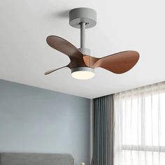 a ceiling fan in a bedroom next to a window