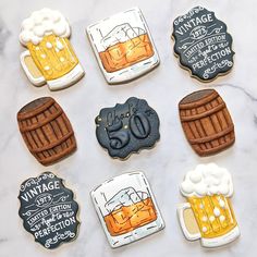 decorated cookies with different types of beer on a marble countertop next to chalk writing