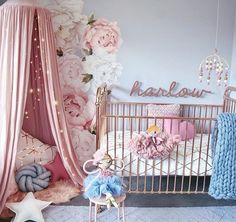 a baby's room decorated in pink and blue with flowers on the wall, crib