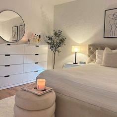 a bedroom with a bed, dresser and mirror on the wall next to each other