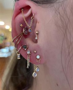 a close up of a person's ear with different types of jewelry on it