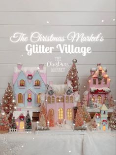 the christmas market's glitter village is set up in front of a white wall