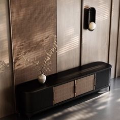 a black cabinet with two white vases on it next to a wooden paneled wall