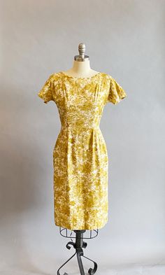 "1950s cotton sateen very fitted day dress. Ivory ground with an all over mustard brush stroke floral print. The neckline is pointed scallops. Top-stitched seams across the bodice, as well as form fitting vertical seams front and back. Cap sleeves, a V-back, with a metal zipper and hook and eye closure. Size- Small Bust - 34\" Waist - 27\" Hips - 39\" Length - 39\" Label: Janice Jr. Condition: Excellent vintage condition. All vintage is sold in \"as-is\" condition. We do our best to inspect, cor Yellow Fitted Dress In 1950s Style, Fitted Yellow Dress In 1950s Style, 1950s Style Yellow Dress For Vintage Fashion, Yellow 1950s Style Dress For Vintage Fashion, Yellow Fitted Vintage Dress 1950s Style, 1950s Style Yellow Dress For Garden Party, Yellow 1950s Style Dress For Garden Party, Fitted Mustard Dress For Daywear, Fitted Vintage Mustard Dress