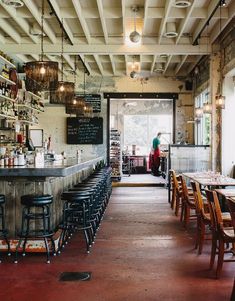 the inside of a restaurant with lots of tables and stools in front of it