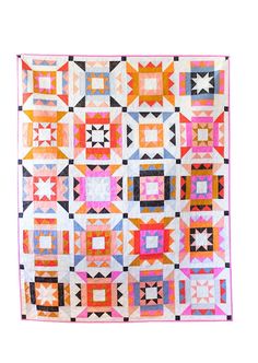 a colorful quilt hanging on the wall in front of a wooden floor and white walls