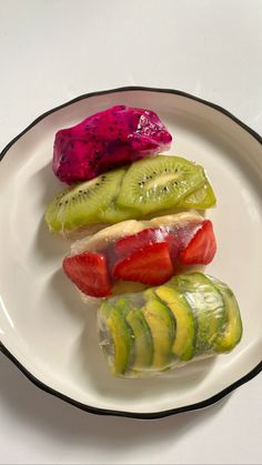 there are four different types of fruit on the plate, including kiwis and strawberries