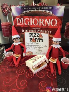 two elfs are sitting in front of a pizza party sign and there is an advertisement for the pizz party