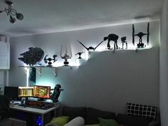 a living room filled with furniture and lots of lights on the wall above it's desk