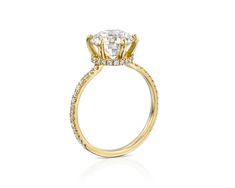 a yellow gold engagement ring with an oval cut diamond and pave set diamonds on the band