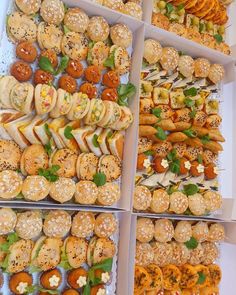 several trays filled with different types of sandwiches and pastries on display for sale