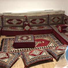 a living room filled with lots of red couches and rugs on the floor