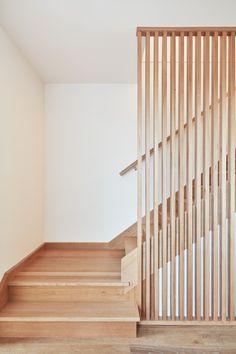 an empty room with wooden stairs and white walls