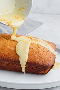 a person pouring sauce onto a loaf of bread