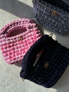 three crocheted purses sitting next to each other on top of a table