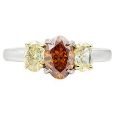 Finely crafted in platinum with a center GIA certified 1.12 carat Fancy Deep Brownish Yellowish Orange diamond. GIA certificate number: 2201779209 The ring features two yellow diamonds weighing approximately a total of 0.60 carats. Yellow Oval Brilliant Cut Diamond Ring, Luxury Platinum Yellow Rings, Luxury Yellow Platinum Rings, Yellow Diamond Cut Platinum Ring, Yellow Brilliant Cut Platinum Ring, Yellow Platinum Diamond Ring With Diamond Cut, Classic Yellow Diamond Ring With Vvs Clarity, Yellow Diamond Platinum Ring With Center Stone, Yellow Platinum Diamond Ring Fine Jewelry