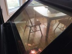 an empty table and chairs in front of a window