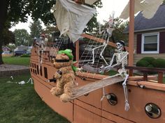 two stuffed animals are sitting on the side of a boat that is decorated with skeletons